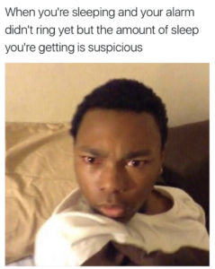 A picture of a man looking over his shoulder with a puzzled glare on his face. The caption reads, "When you're sleeping and your alarm didn't ring yet but the amount of sleep you're getting is suspicious.