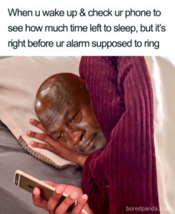A picture of Michael Jordan crying in bed while looking a cell phone. The caption reads: "When u wake up & check ur phone to see how much time left to sleep, but it's right before ur alarm supposed to ring."
