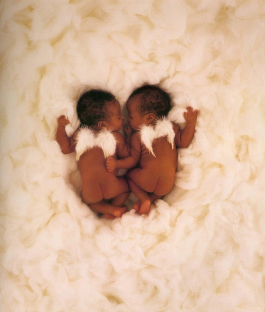 anne geddes photo of two babies sleeping on a pile of feathers wearing angel wings