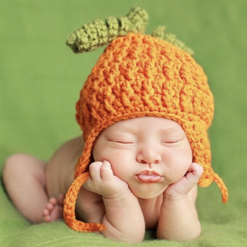 anne geddes photo of a baby with a pumpkin hat on