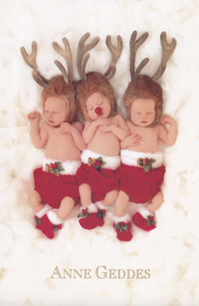 anne geddes photo of three babies dressed up as reindeer while napping