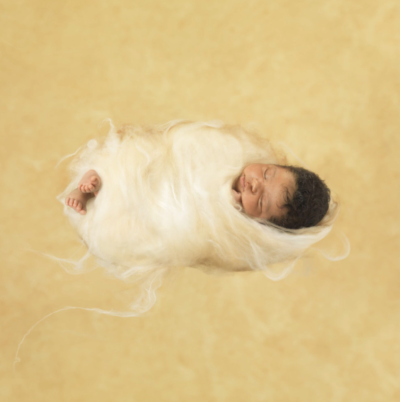 anne geddes photo of a baby wrapped in a yarn cocoon