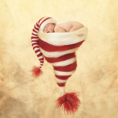 anne geddes photo of a baby sleeping inside of a stocking cap