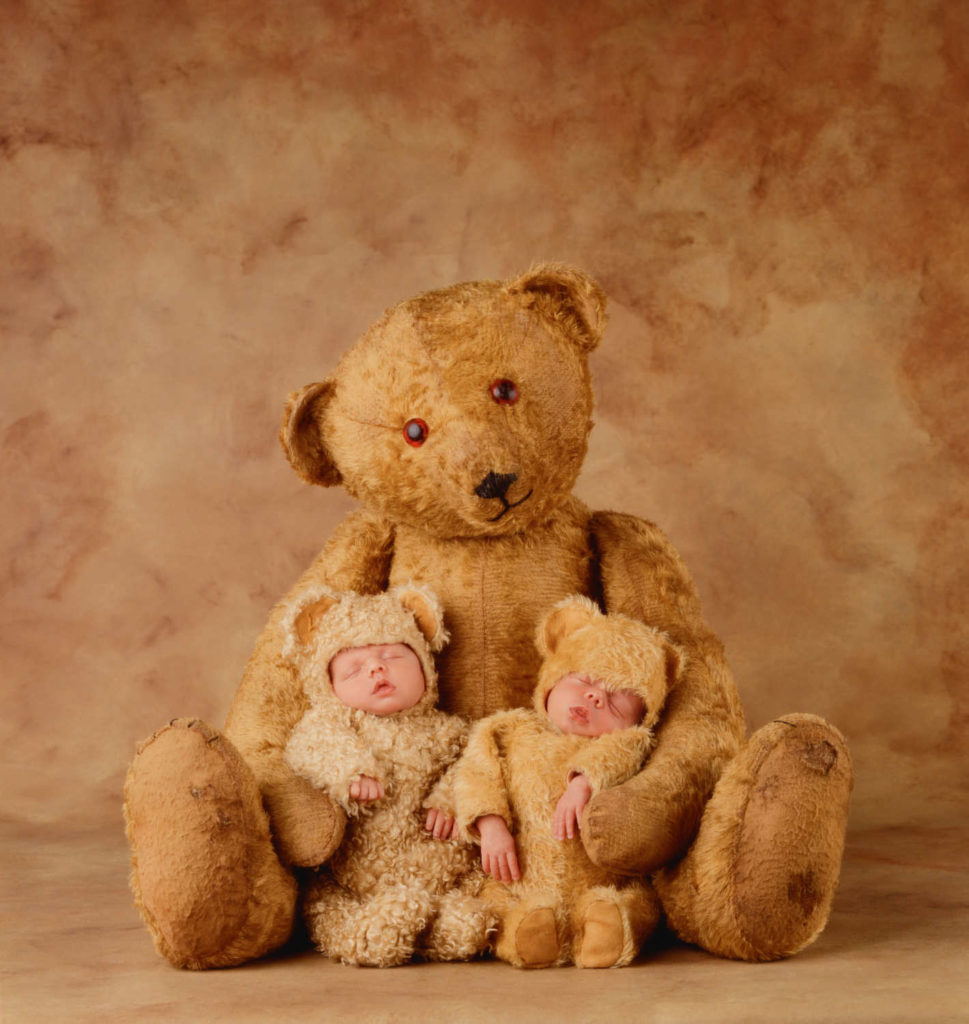 anne geddes photo of two babies in bear costumes by a teddy bear
