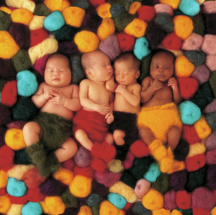 anne geddes photo of four babies in a pile of yarn