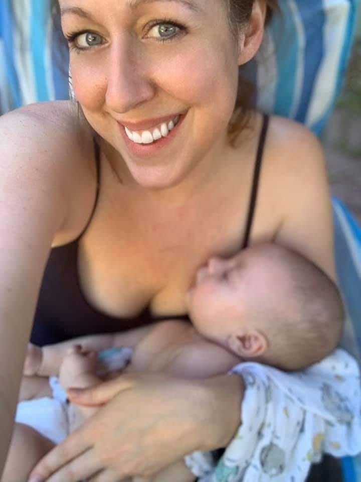a happy woman holds her infant