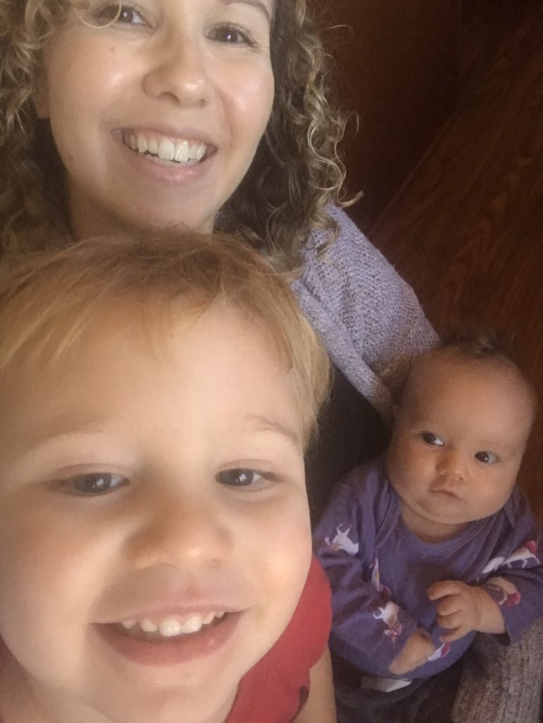 a mom takes a selfie with her two kids