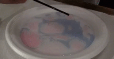 gif of colors shifting in a liquid as a straw touches it
