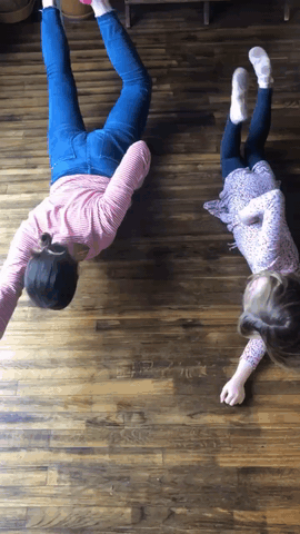 a mom and her daughter pose like superheroes flying on the ground