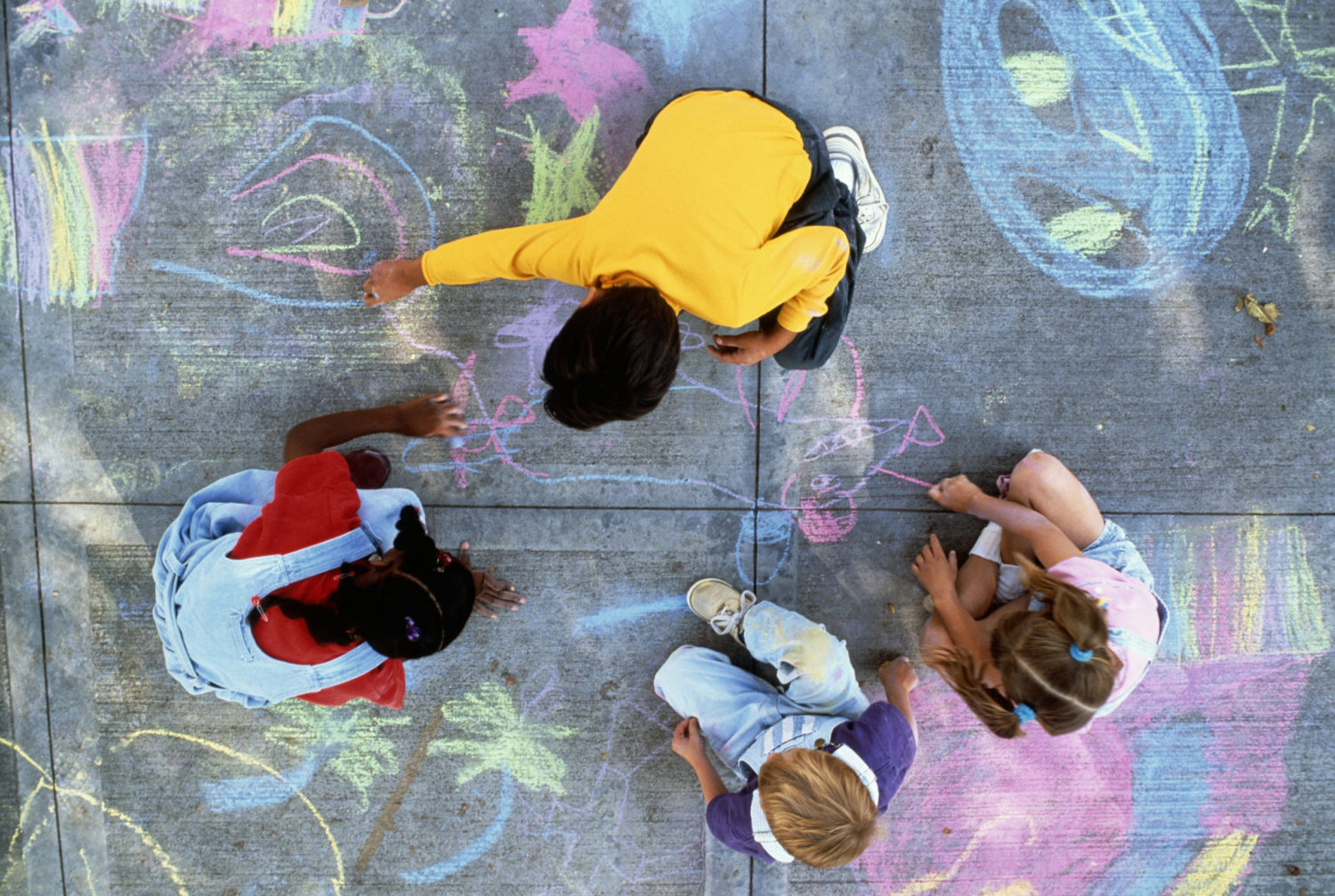 Kids play together with chalk during a nanny share.