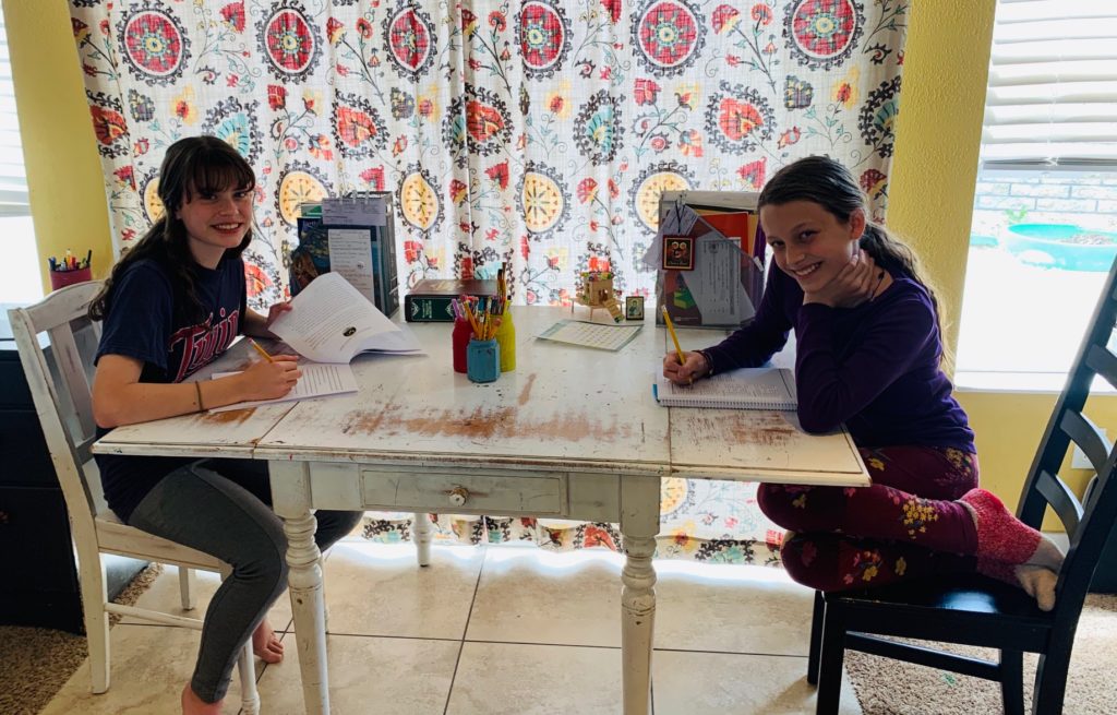 two girls working on schoolwork at home