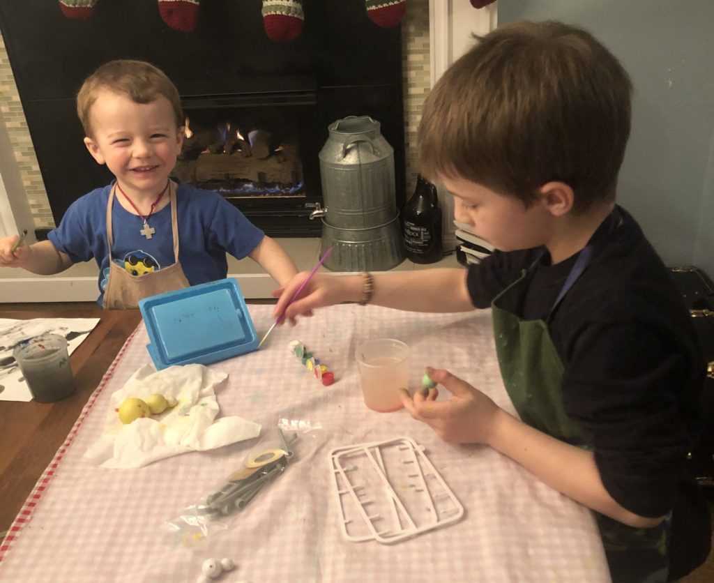 two boys work on craft projects at home