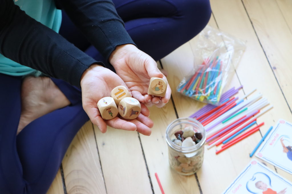 a woman holds yoga dice in her hands