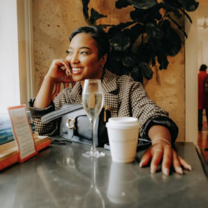 a happy young woman sits in a cafe