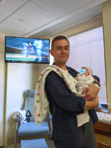 A father holds his newborn baby in the hospital.