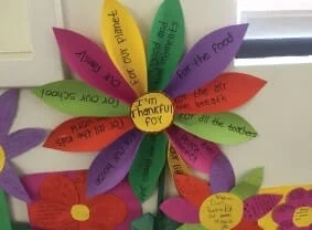 a flower made from paper with writing on each petal