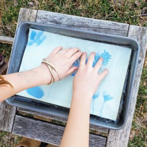 Soaking the sun print in water to wash off chemicals.