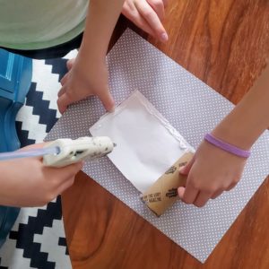 DIY Kaleidoscope: Use hot glue to attach the paper to the tube